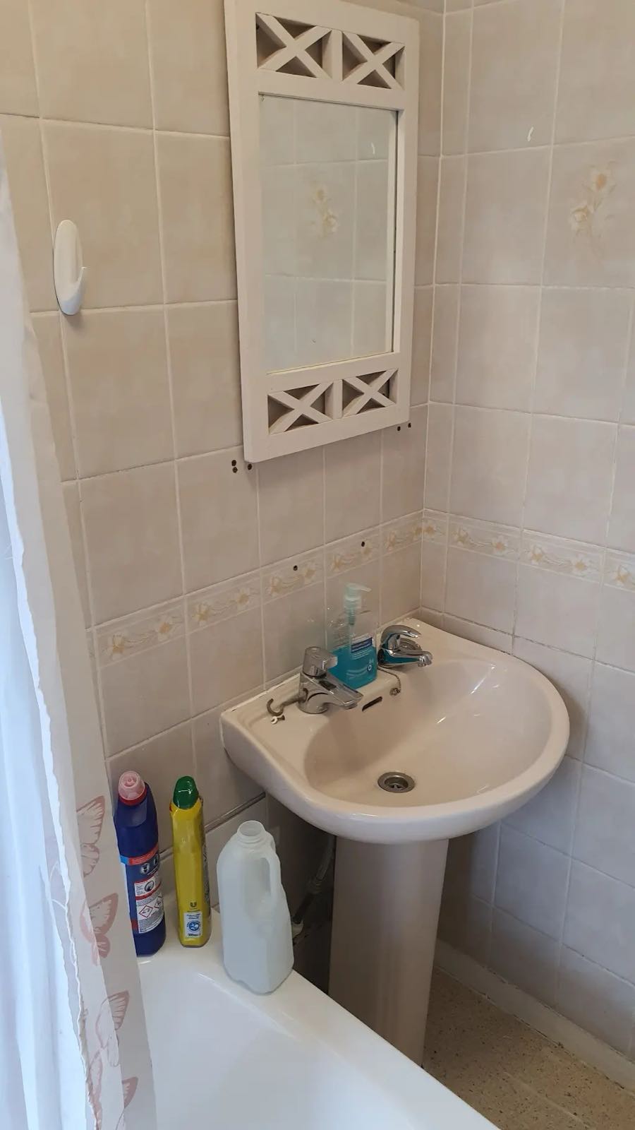 Before: the old peach-tiled bathroom with pedestal basin