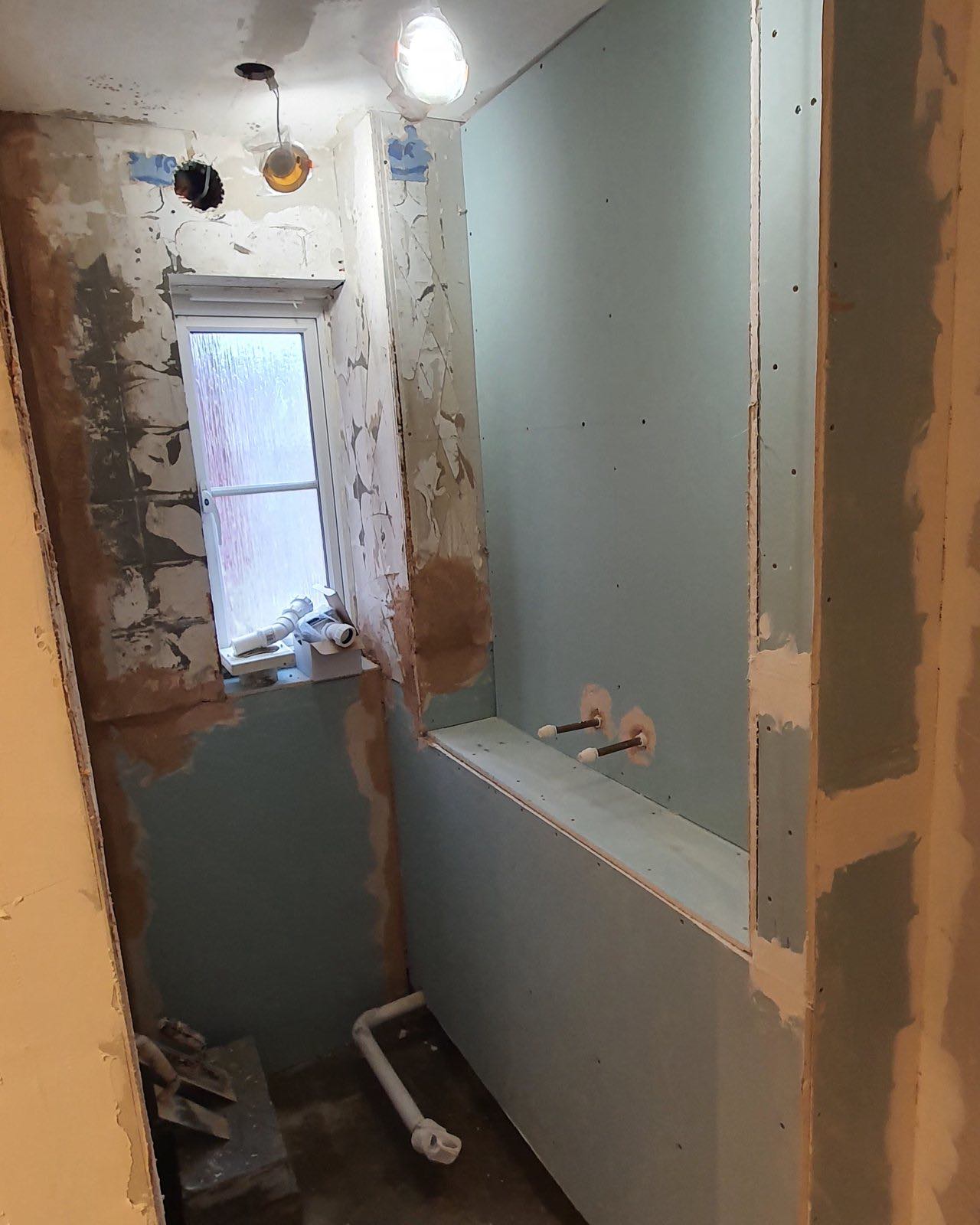 Before: the en-suite stripped back to bare boards and plasterboard