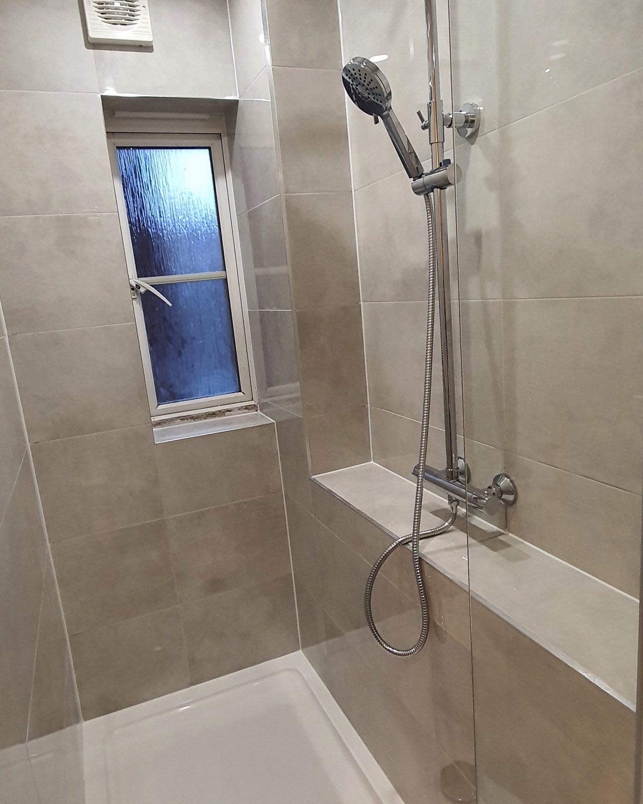 After: the finished shower end with large-format tiles, rainfall shower and extractor by ATR Kitchens and Bathrooms