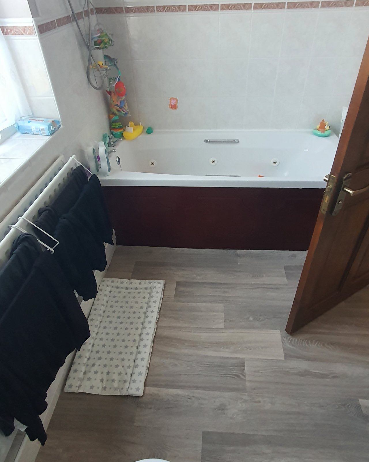 Before: the old bath with peach tiles and a worn floor
