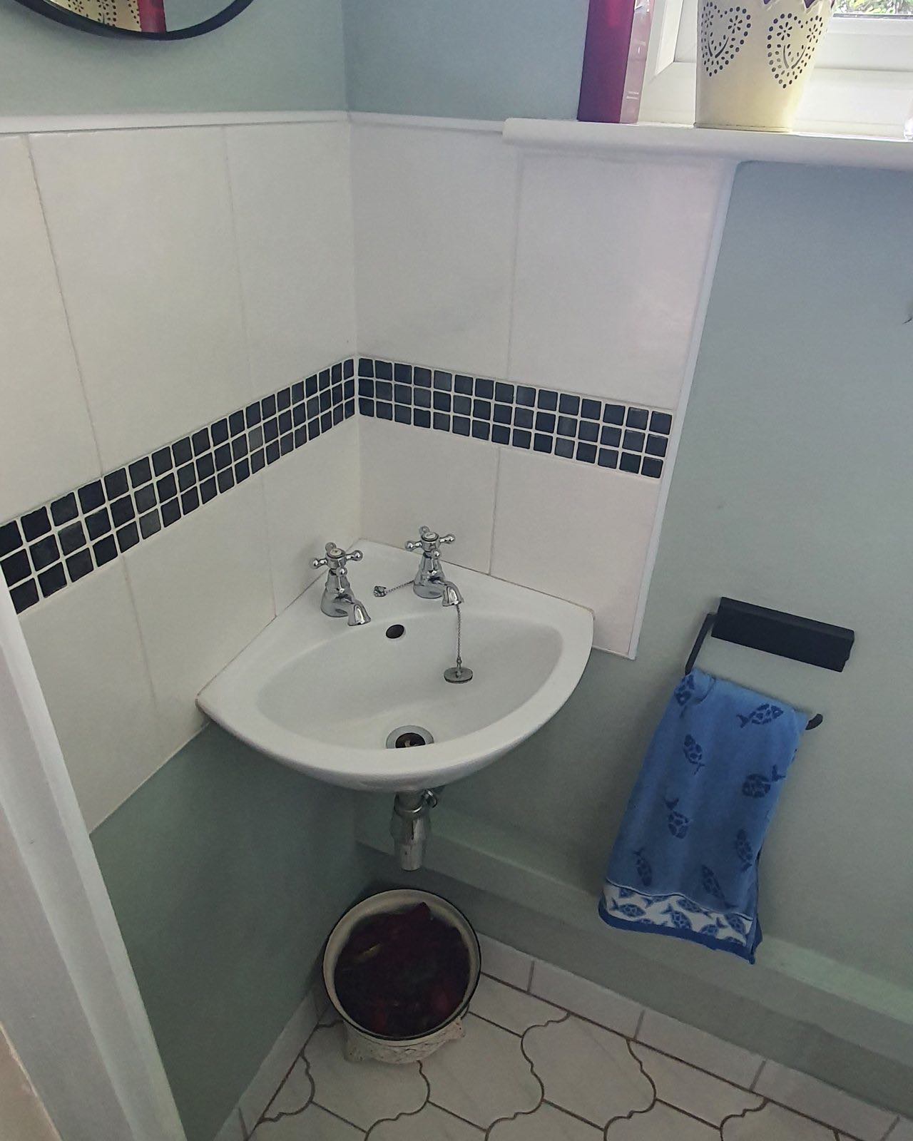 Before: the old cloakroom with a corner basin, mosaic border tiles and hexagonal floor