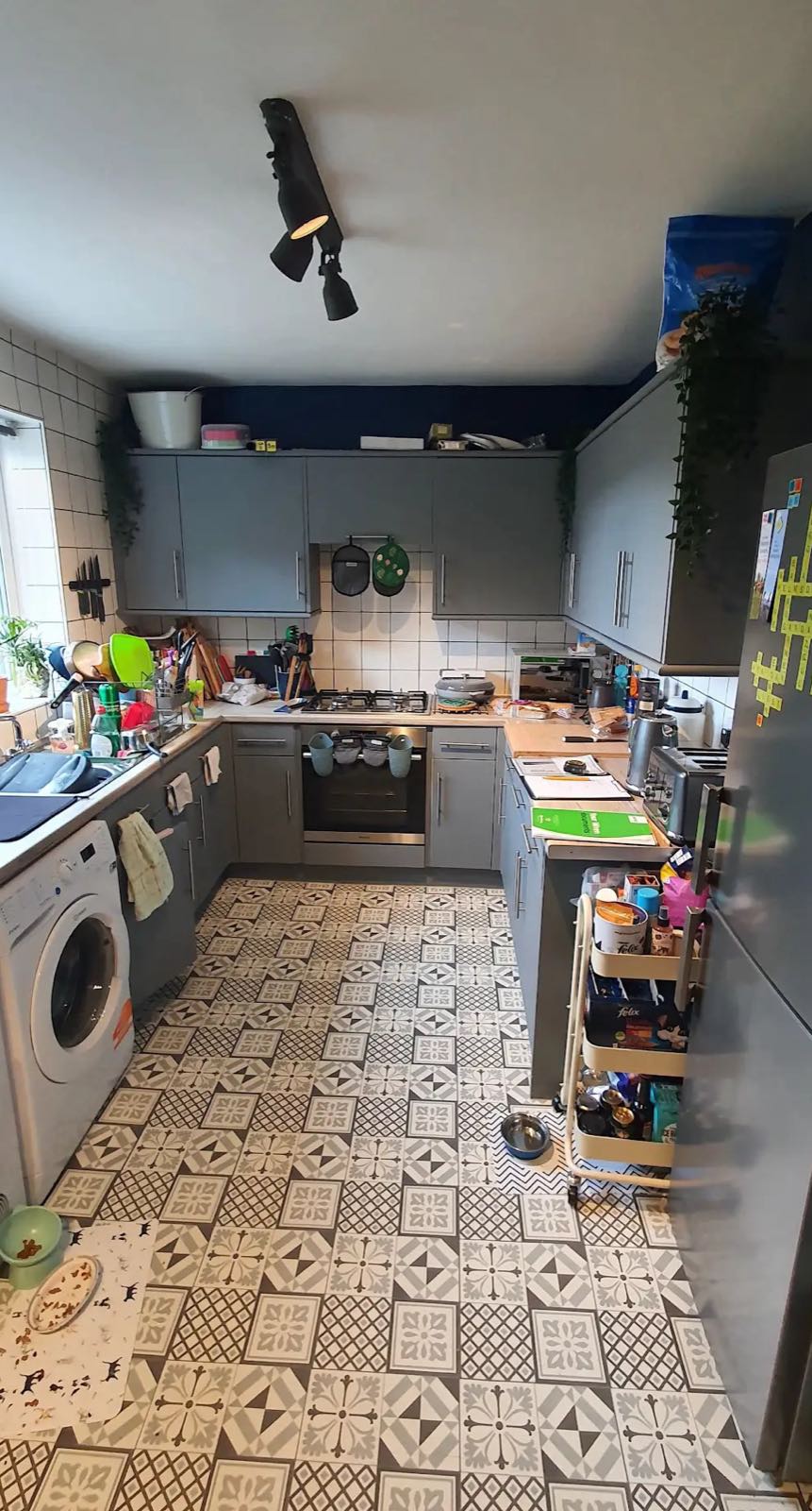 Before: the old grey kitchen with patterned floor tiles and a washing machine