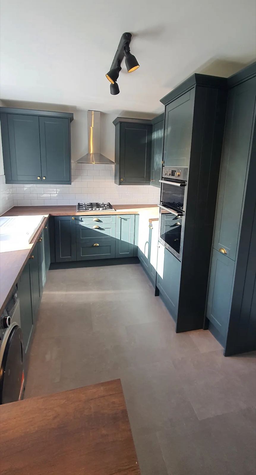 After: the refitted kitchen with navy shaker units, white worktop and new flooring by ATR Kitchens and Bathrooms