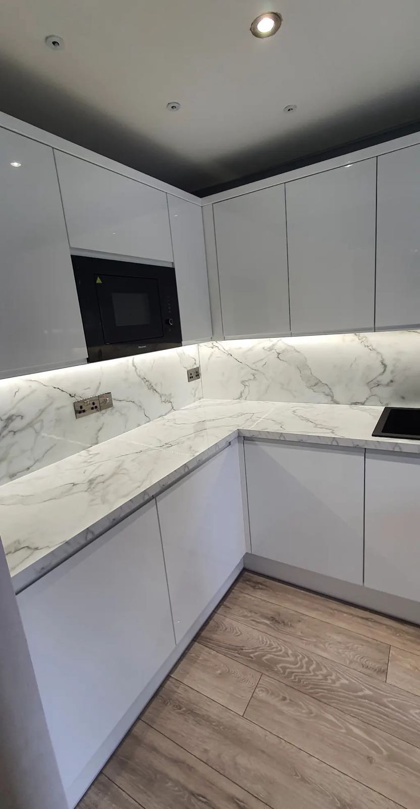 After: the same kitchen refitted with white handleless units, marble-effect worktop and splashback by ATR Kitchens and Bathrooms