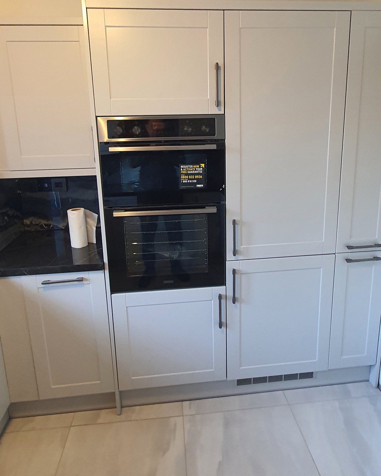 After: the finished shaker kitchen with tall housings, built-in oven and black worktop by ATR Kitchens and Bathrooms