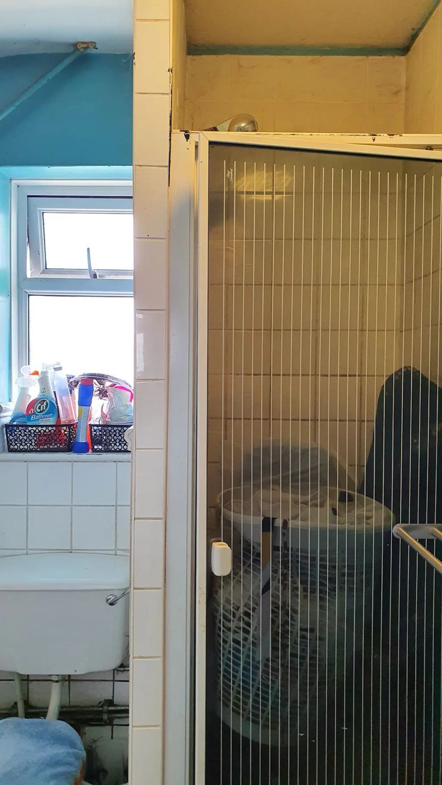 Before: the old shower cubicle with a folding door and teal walls