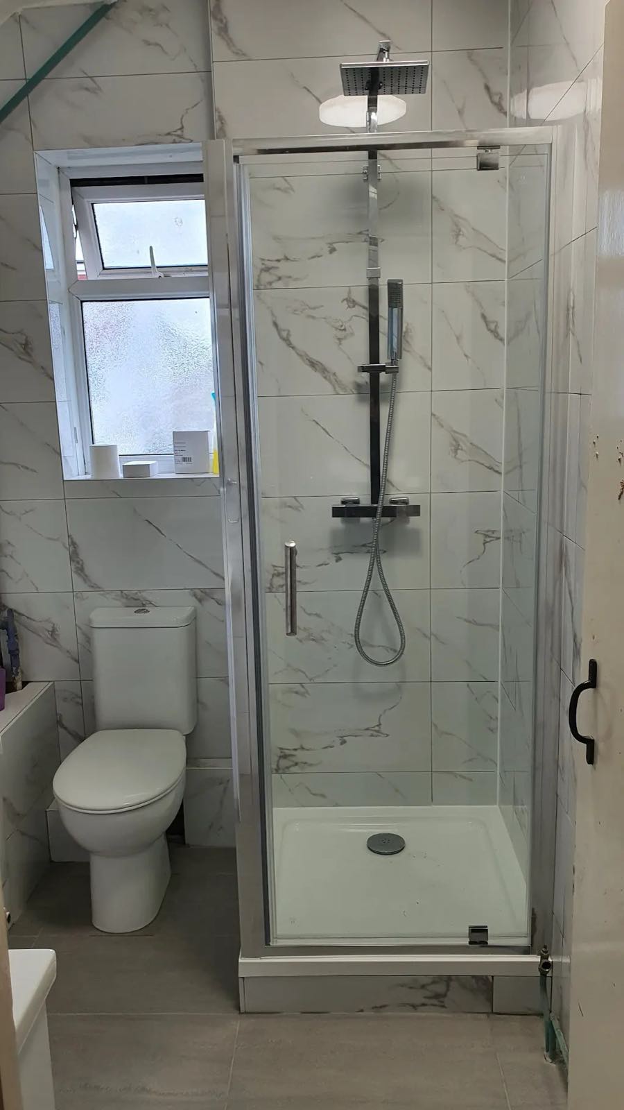 After: the new marble-effect tiled shower with glass door and rainfall shower by ATR Kitchens and Bathrooms